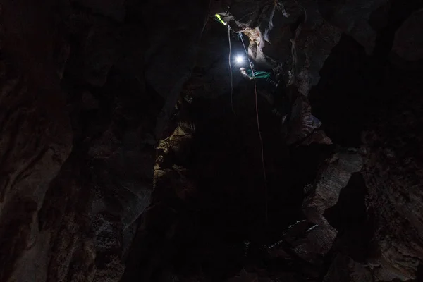 Turista entrando na caverna na corda — Fotografia de Stock