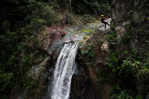 Man doing mountain climbing on waterfall — Stock Photo, Image