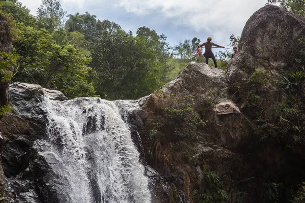 Man doing mountain climbing on waterfall — Stock Photo, Image