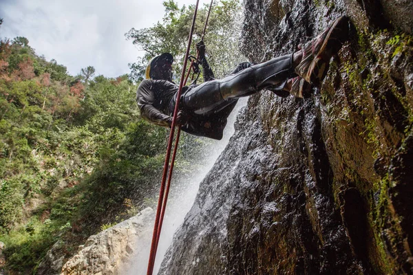 Homem fazendo montanhismo na cachoeira — Fotografia de Stock