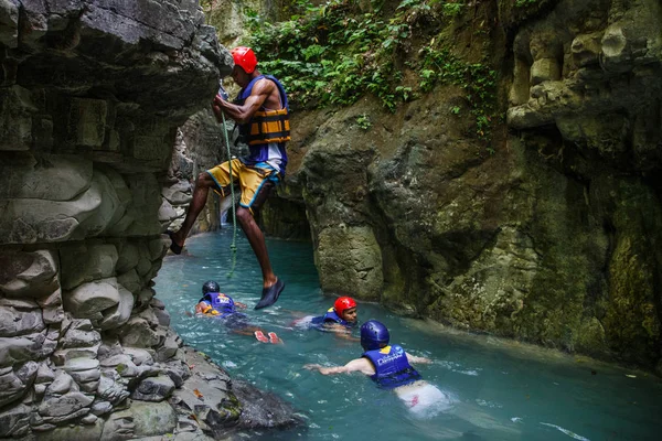 Tourists climbing and swimming in cave — Stock Photo, Image
