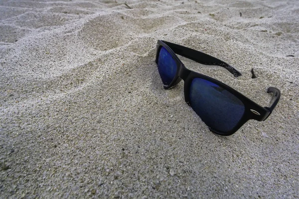 Eenzame zonnebril liggend op een zandstrand — Stockfoto