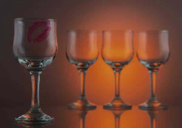 Red lipstick kiss on one glass of four — Stock Photo, Image