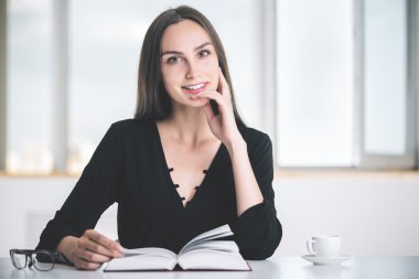 Açık kitap ile gülümseyen kadın