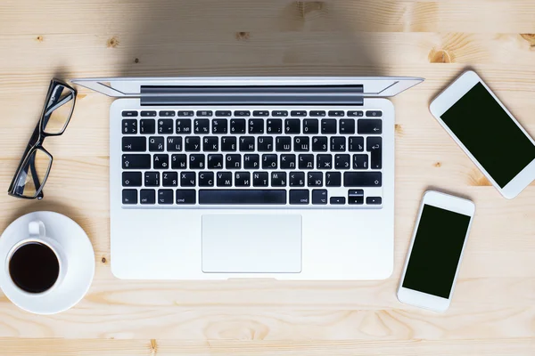 Laptop e smartphones na área de trabalho — Fotografia de Stock