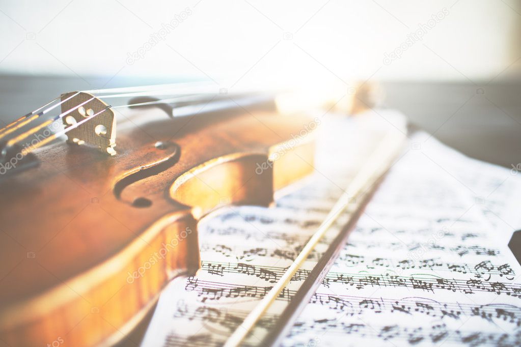 Closeup of retro violin, bow and music sheets. Concert concept