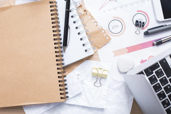 Messy workplace with empty notepad — Stock Photo, Image