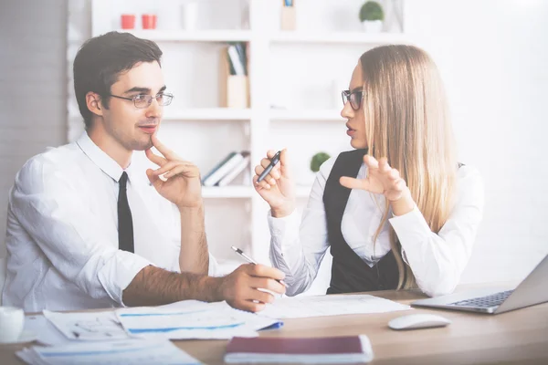 Aantrekkelijke jonge zakenman en vrouw in formele outfits doen papierwerk in moderne kantoor. Teamwork concept — Stockfoto