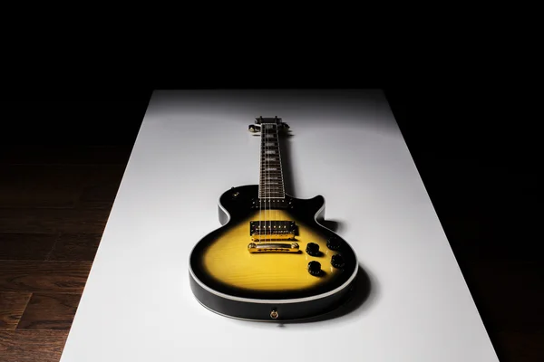 Guitarra Sunburst na mesa branca — Fotografia de Stock