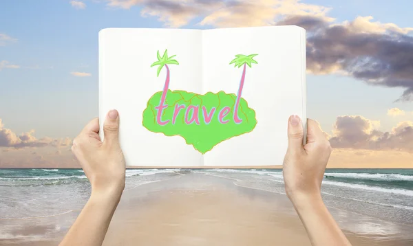Manos sosteniendo libro con dibujo creativo de viajes en el fondo de la playa. Concepto de vacaciones —  Fotos de Stock