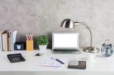 Hipster çalışma alanı boş beyaz dizüstü ekran, elektronik cihazlar, calsulator, saati, Masa lambası, sarf malzemeleri ve diğer öğeleri ile önden görünümü. 