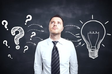 Yaratıcı ampul ve soru işaretleri kroki ile tahta arka plan üzerinde düşünen yakışıklı genç erkek. Fikir kavramı