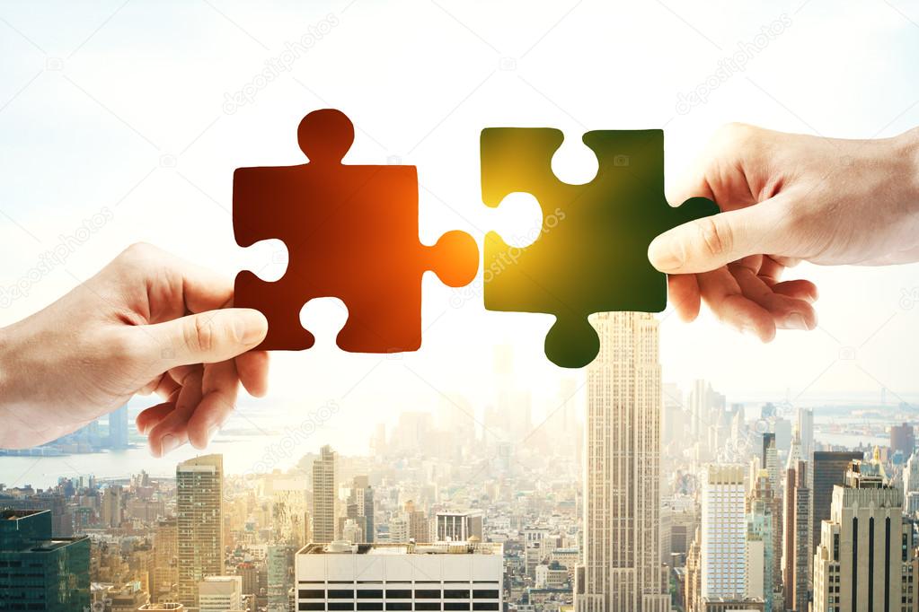 Hands putting puzzle piece together on bright city background with sunlight. Partnership concept