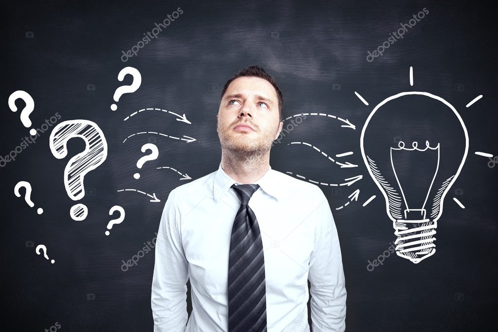 Handsome young male thinking on blackboard background with creative light bulb and question marks sketch. Idea concept