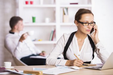 Young female on phone doing paperwork