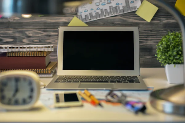 Área de trabalho com laptop e objetos embaçados — Fotografia de Stock