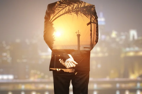 Vista trasera de un joven empresario soñando con vacaciones en un fondo borroso de la ciudad nocturna. Concepto de vacaciones. Doble exposición —  Fotos de Stock