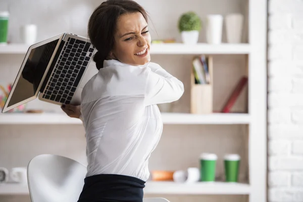 Портрет разъяренной молодой женщины, готовой бросить и сломать ноутбук на рабочем месте. Концепция стресса — стоковое фото