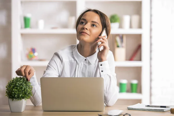 Frau am Arbeitsplatz telefoniert — Stockfoto