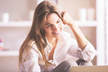 Dizüstü bilgisayar kullanan iş kadını gülümseyen