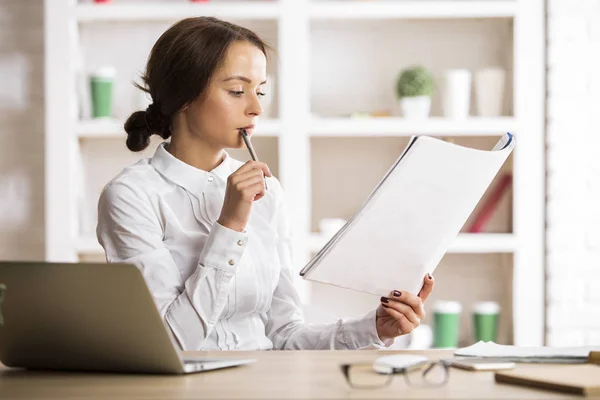 Mujer pensativa haciendo papeleo — Foto de Stock