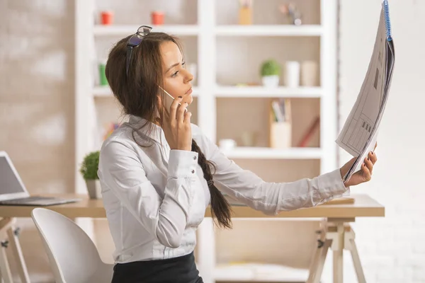 Geschäftsfrau schaut sich am Telefon Projekt an — Stockfoto