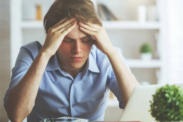 Portrait of  worried young businessman at workplace. Stress concept — Stock Photo, Image