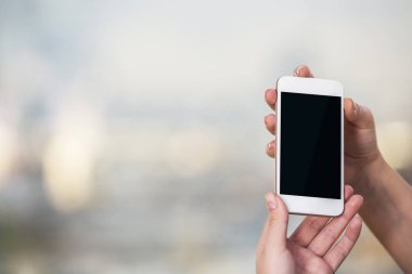 Boş smartphone kızın elinde. Bulanık arka plan kopya alanı ile. Yukarı alay