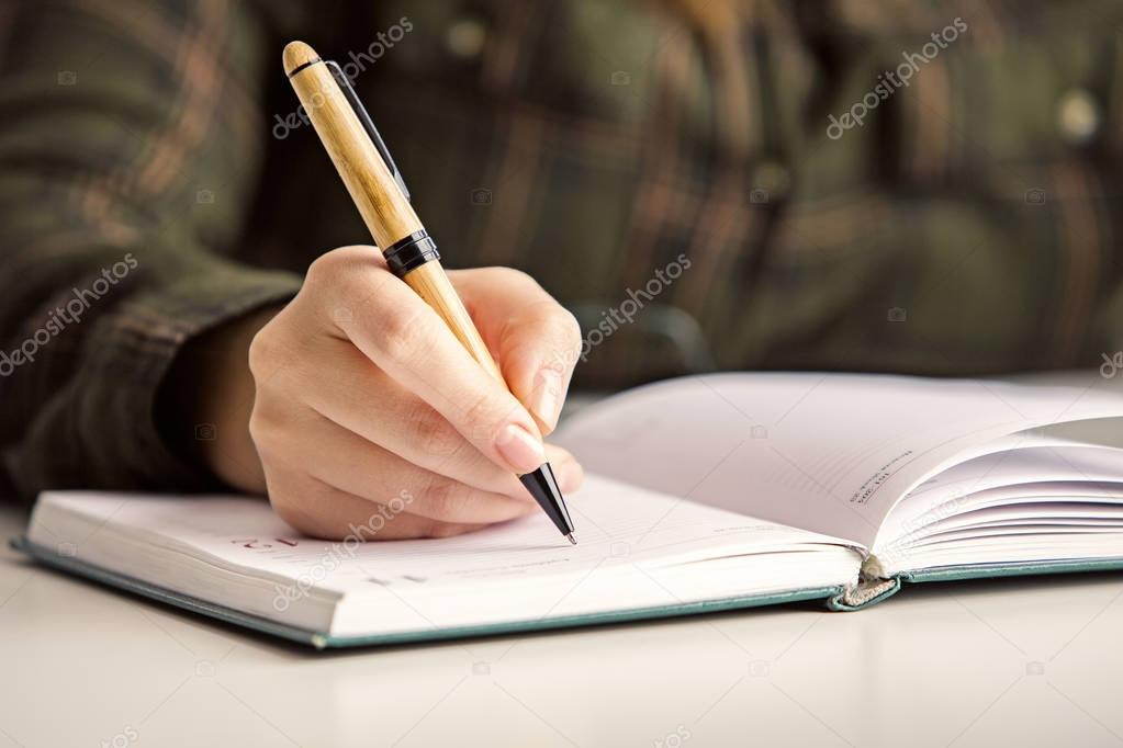Woman writing in organizer
