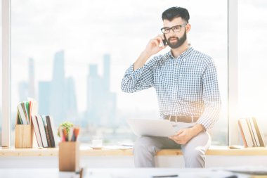 Dizüstü bilgisayar kullanarak telefon yakışıklı işadamı