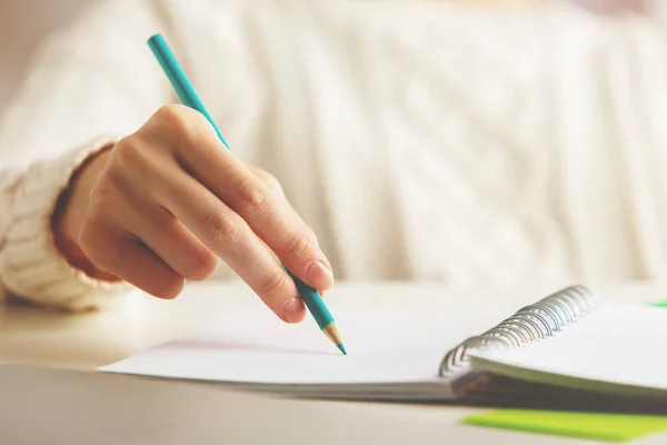 Female writing in spiral notepad — Stock Photo, Image