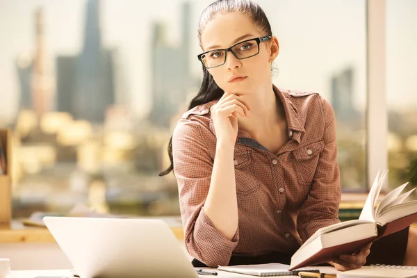 Chica bastante caucásica leyendo libro en el lugar de trabajo. Concepto de conocimiento —  Fotos de Stock