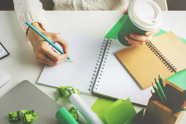 Mujer con escritura de café en bloc de notas — Foto de Stock