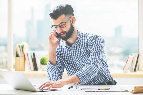 Schöner Kerl am Telefon mit Laptop — Stockfoto