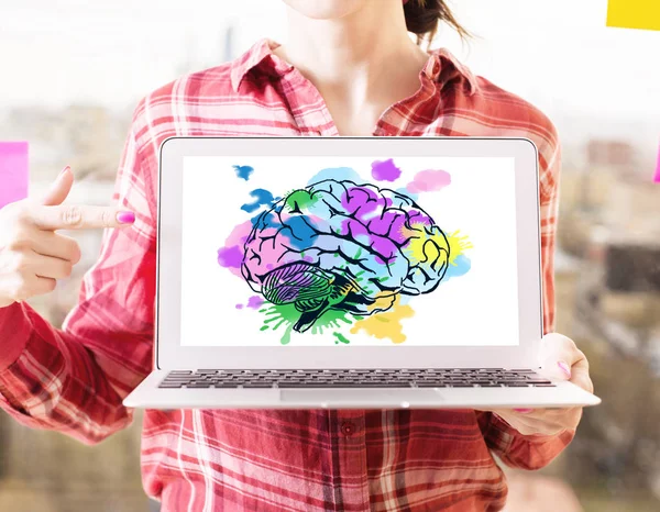 Женщина тычет в ноутбук творческим красочным человеческим мозговым рисунком. Концепция мозгового штурма — стоковое фото