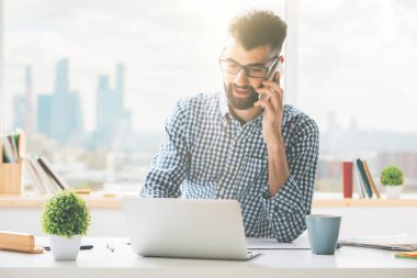 Dizüstü bilgisayar kullanarak telefon yakışıklı adam