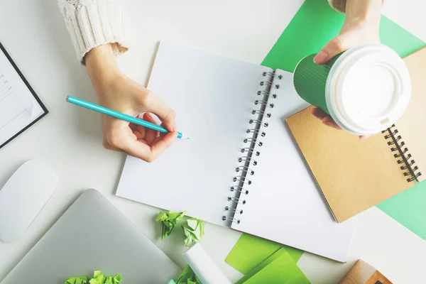 Mujer con café escribiendo en bloc de notas — Foto de Stock