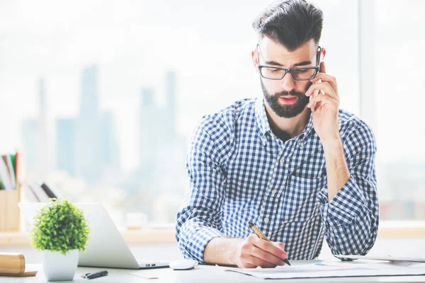 Guy on phone doing paperwork