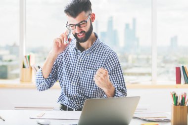İşyeri telefon ve gösteren yumruk, 'Evet' jest konuşmak yakışıklı genç çocuk. Başarı kavramı 