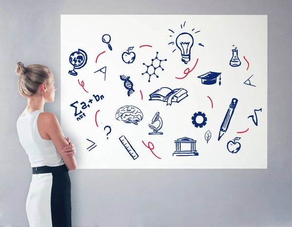 Zijaanzicht van elegante jonge vrouw op zoek naar whiteboard met wetenschappelijke tekeningen. Onderwijs concept — Stockfoto
