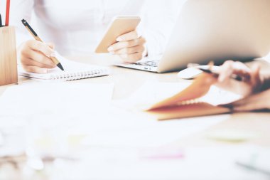 Evrak işlerini yapıyor ve cep telefonu kullanarak eller