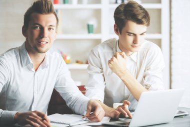 Ekip çalışması kavramı. Modern ofis proje üzerinde iki çekici Avrupa bey portresi.