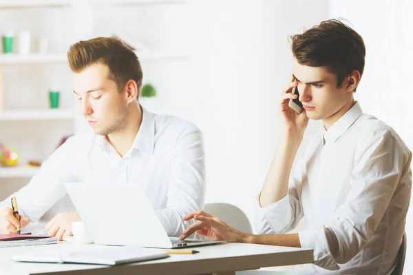 Retrato de caballeros europeos guapos en el lugar de trabajo trabajando en el proyecto y hablando por teléfono móvil. Concepto de trabajo en equipo — Foto de Stock