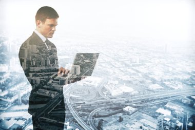 Soyut resim dizüstü kullanarak şehir arka plan üzerinde beyaz erkek. Çift pozlama. İletişim kavramı