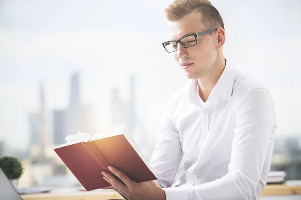 Portrait du beau livre de lecture masculin caucasien sur le lieu de travail. Concept d'éducation — Photo