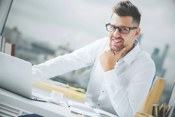 Hombre de negocios sonriente en el lugar de trabajo —  Fotos de Stock