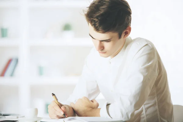 Biznesmen pisze w notatniku — Zdjęcie stockowe