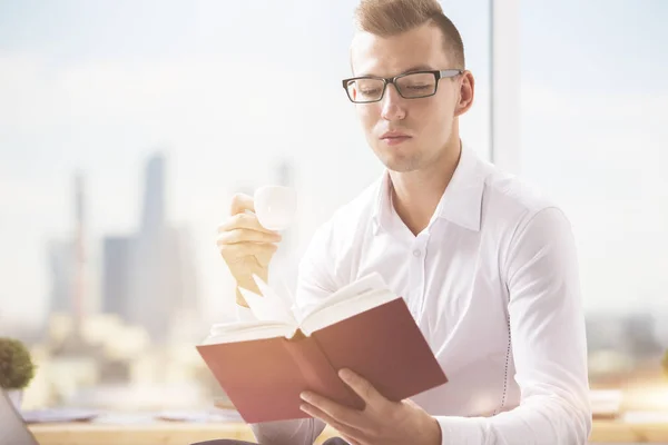 Portrait d'un bel homme caucasien lisant un livre sur le lieu de travail. Concept d'éducation — Photo