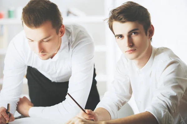 Teamwork. zwei attraktive junge kaukasische Jungs, die im modernen Büro Büroarbeit erledigen — Stockfoto