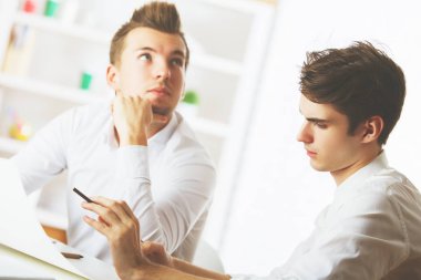 Ekip çalışması kavramı. İki çekici genç beyaz adam modern ofis evrak işi yapıyor